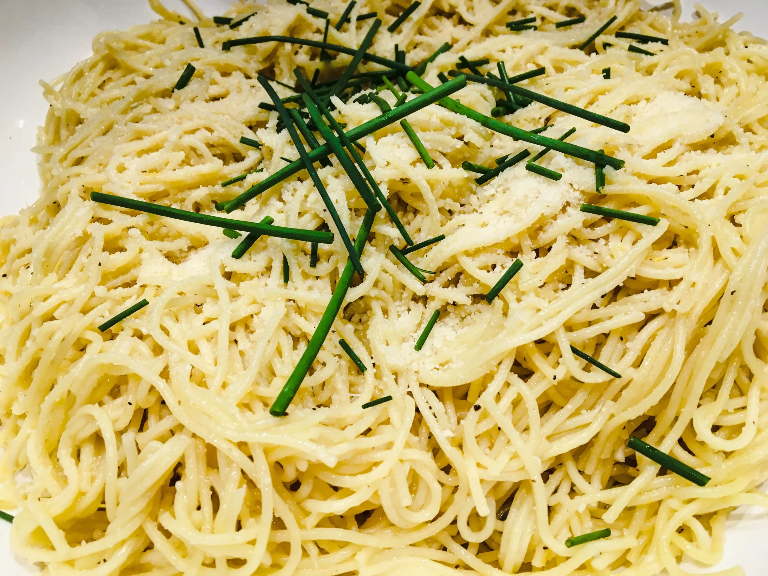 Angel Hair Pasta with Lemon Garlic Butter finished with grated parmesan cheese and fresh chives