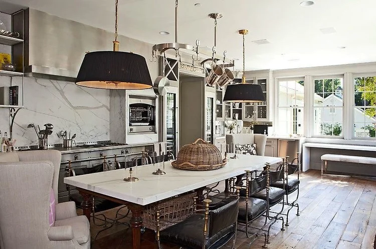 Vintage Jansen armchairs chosen for the center island are the perfect period style pieces to add a feeling of European hierarchy to the kitchen's contemporary finishes. The solid oak floors by Exquiste Surfaces, chosen for multiple areas of the home invigorates a rustic look against the fresh white walls and gray cabinetry.