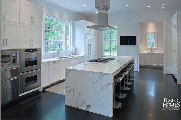  Kitchen features a sleek Calacatta marble island and stainless-steel Dacor, Sub-Zero, and Miele appliances. 