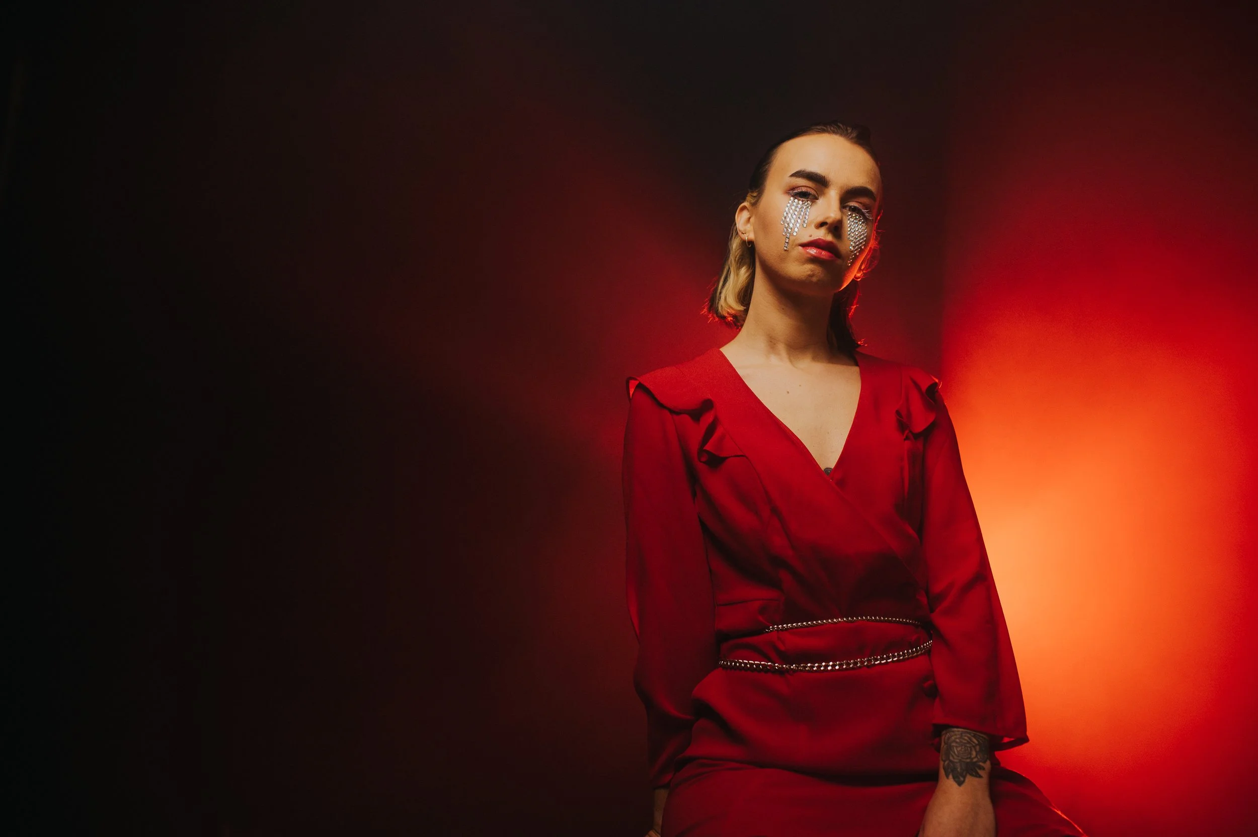 Female singer in red dress with a hazy red light behind