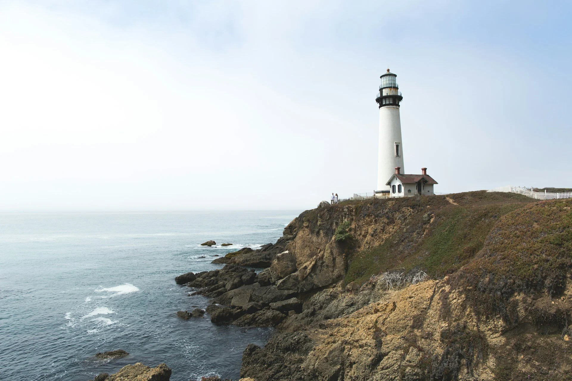 Coastal lighthouse on rocky cliff overlooking Pacific Ocean, Northern California