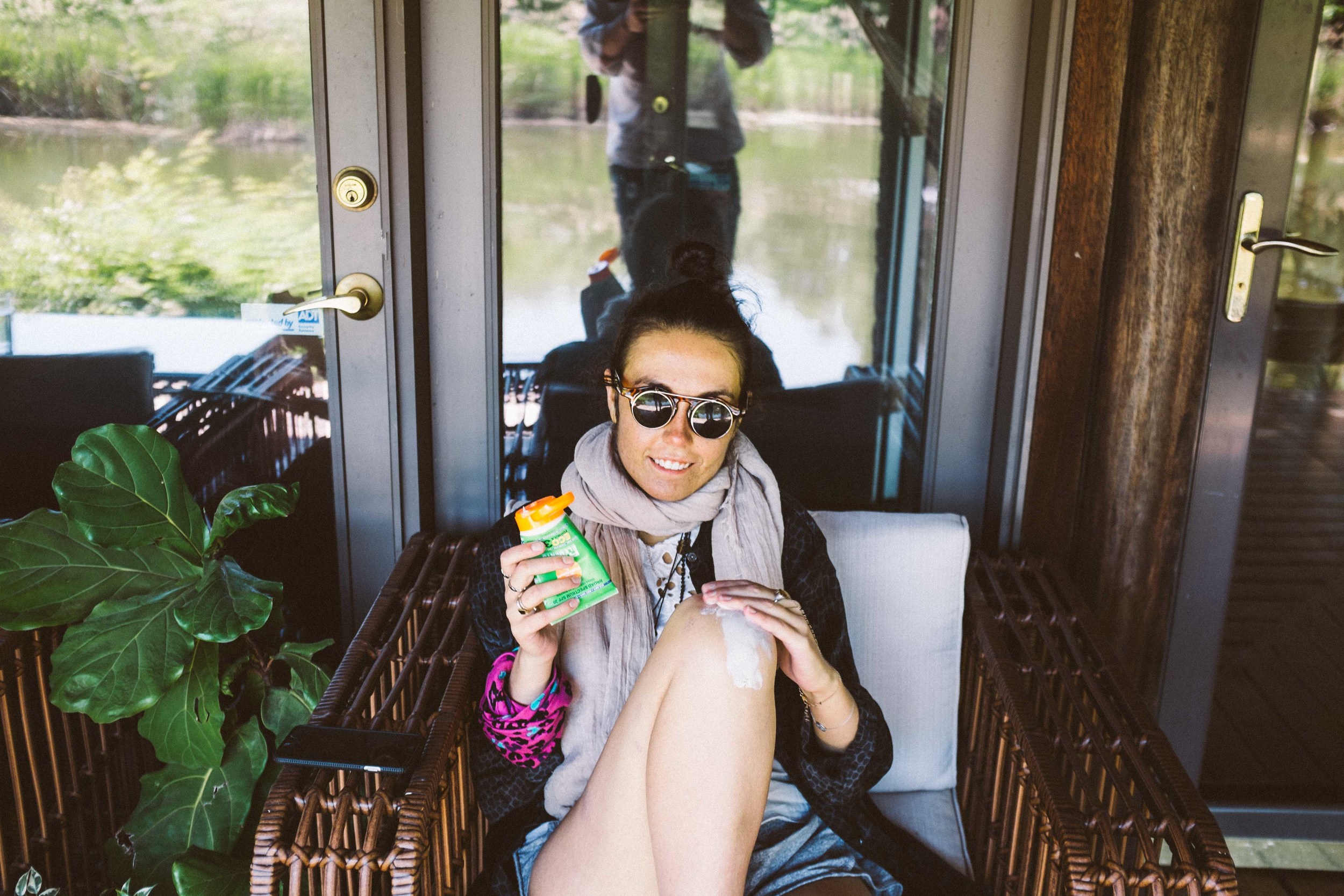 Just casually applying some sunscreen by a pond wearing a scarf in June with shorts to balance it out. Photo by Lenny Kohlmayer