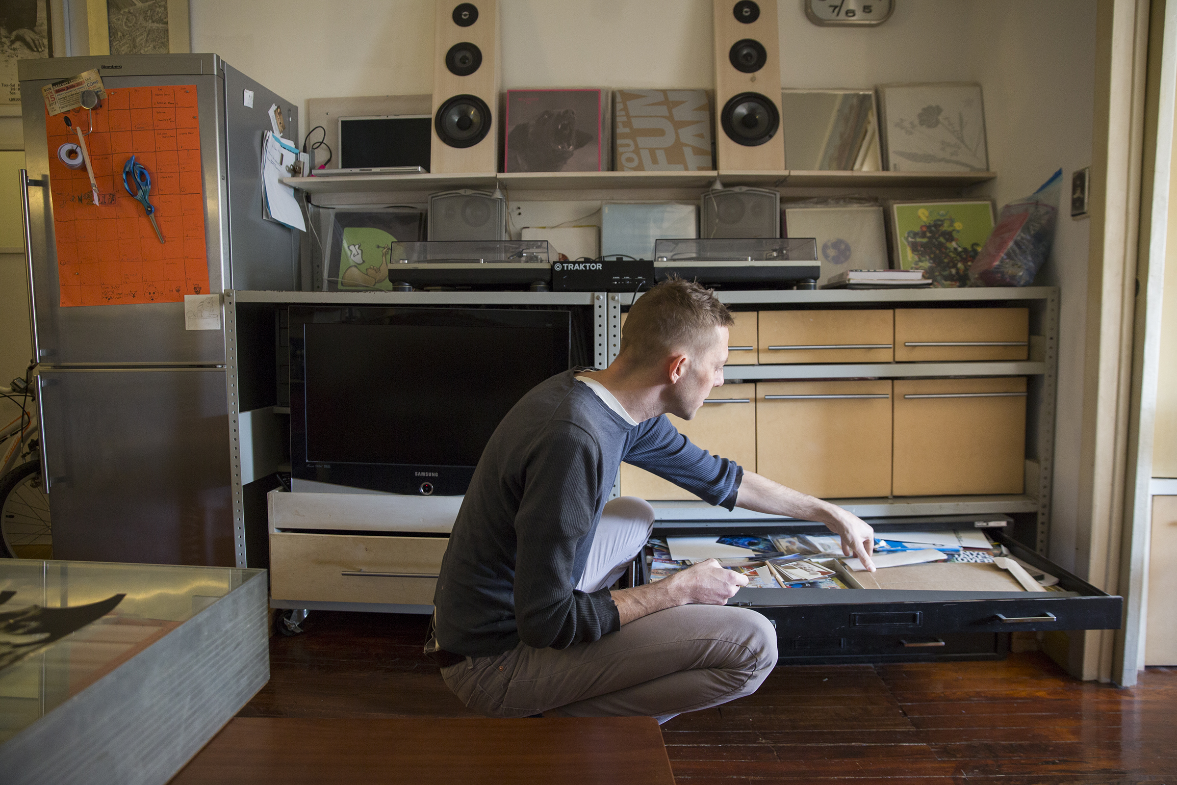 Anselm goes through his flat files for paper to print on. He keeps much of his archive in these files, over which are his turntables, speakers, and records. He custom built these shelves to suit the space.