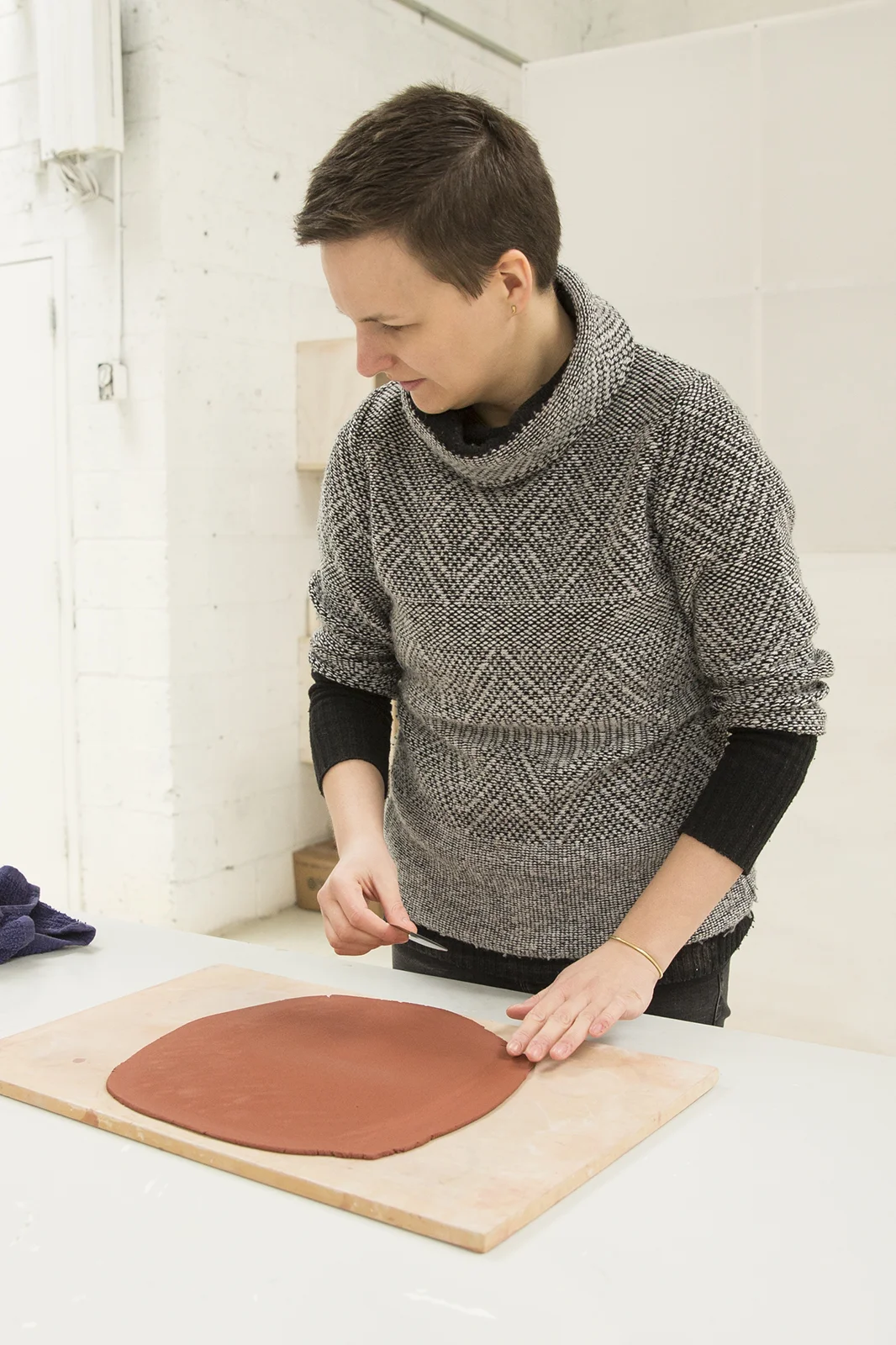  Karolina checks the thickness of the slab as she uses a scraper to smooth the surface.  