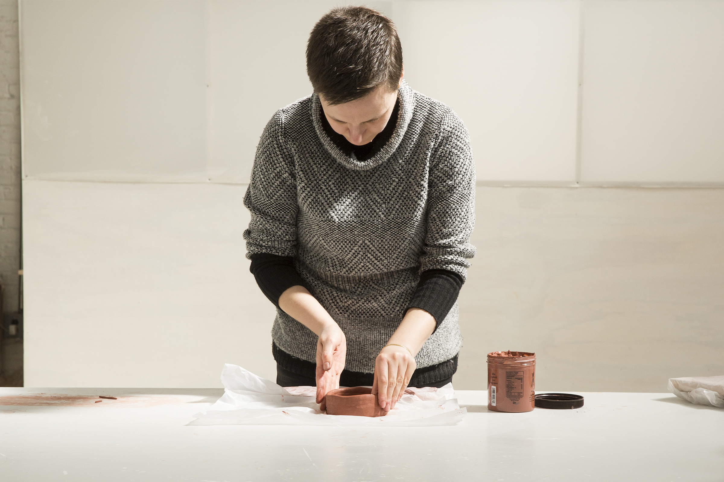 Building up the coil on the mug base. She smooths the inside and outside as she goes to create a clean surface.