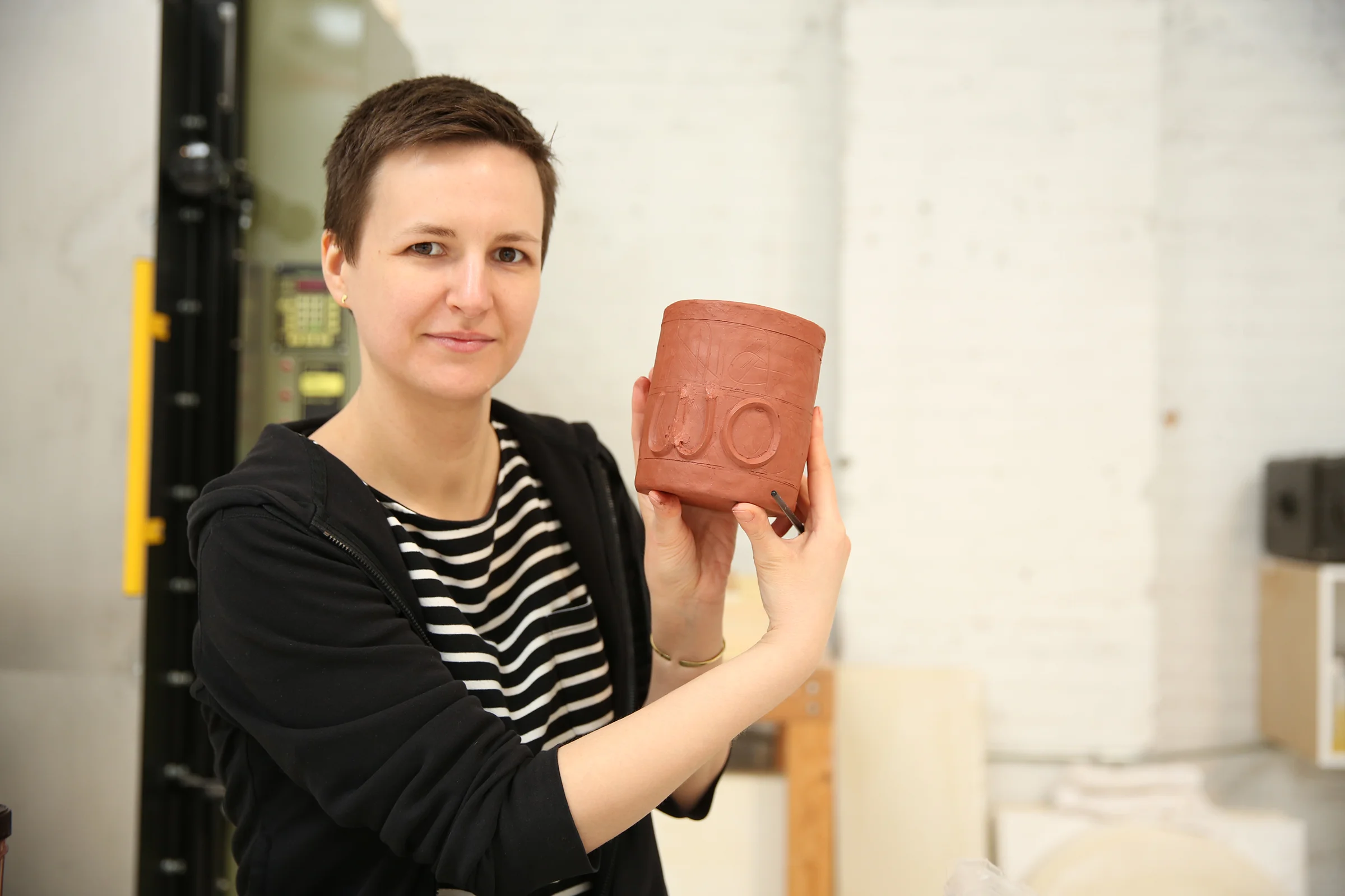 Karolina has applied strips of clay to create a 3-D relief-like effect for the lettering on this mug. It will say “Nasty Woman;” a term that was used by Trump to describe Hillary Clinton during the third Presidential debate in 2016. It instantly bec