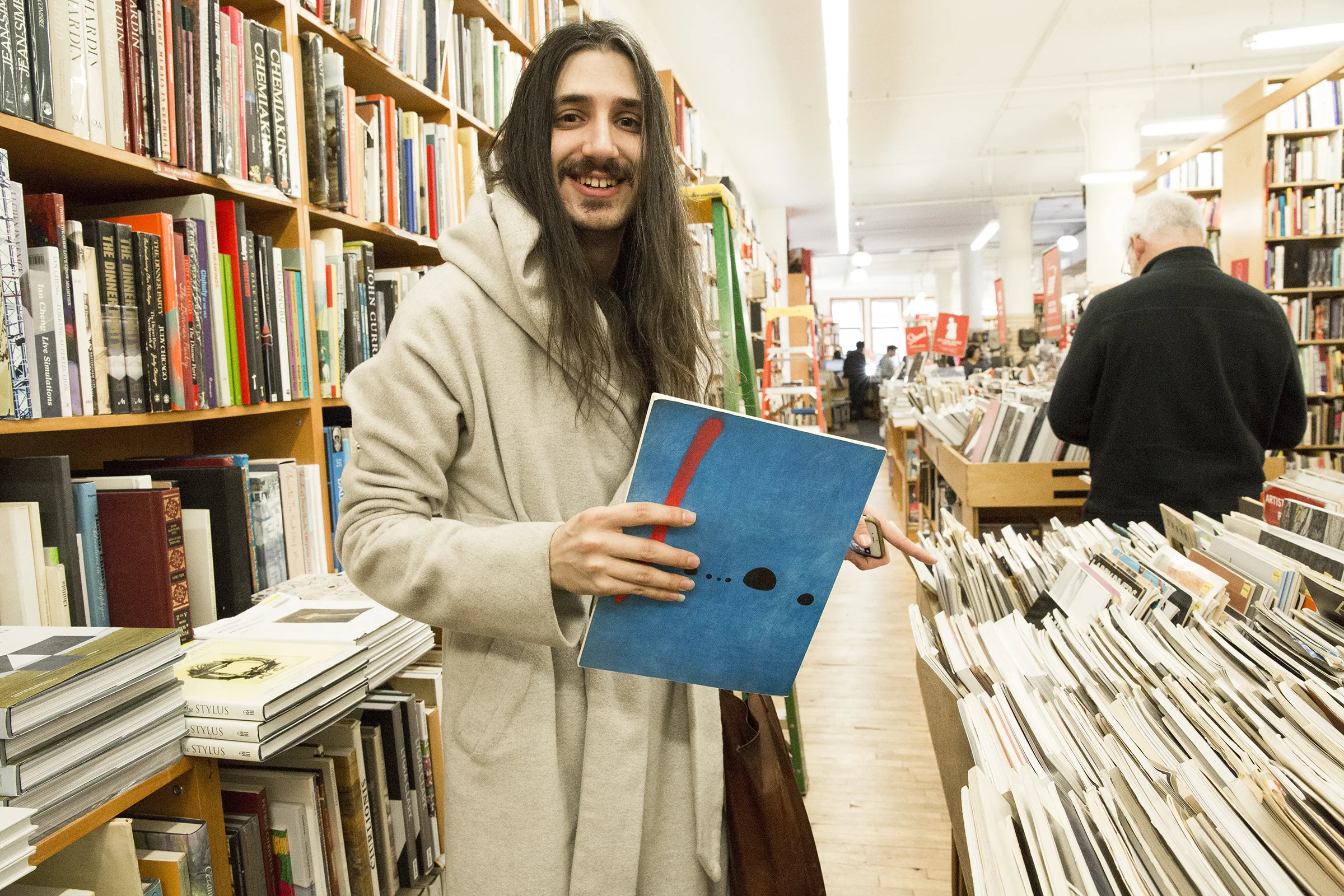  Aaron browses the used book section. The Joan Miró “Blue” painting on back cover of the book they’re holding happens to be a poster in their room. 