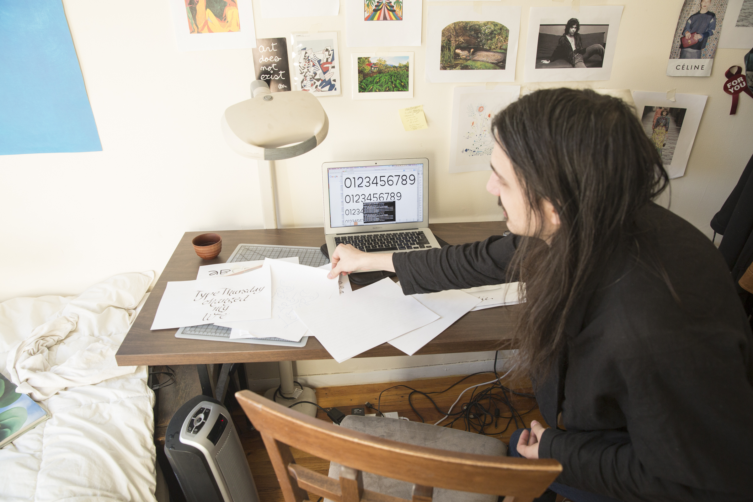 Aaron goes through calligraphy exercises and type sketches. A typeface they’re working on is visible on the computer screen. They studied under type master Tony DiSpigna, who was a big influence on their calligraphic style.