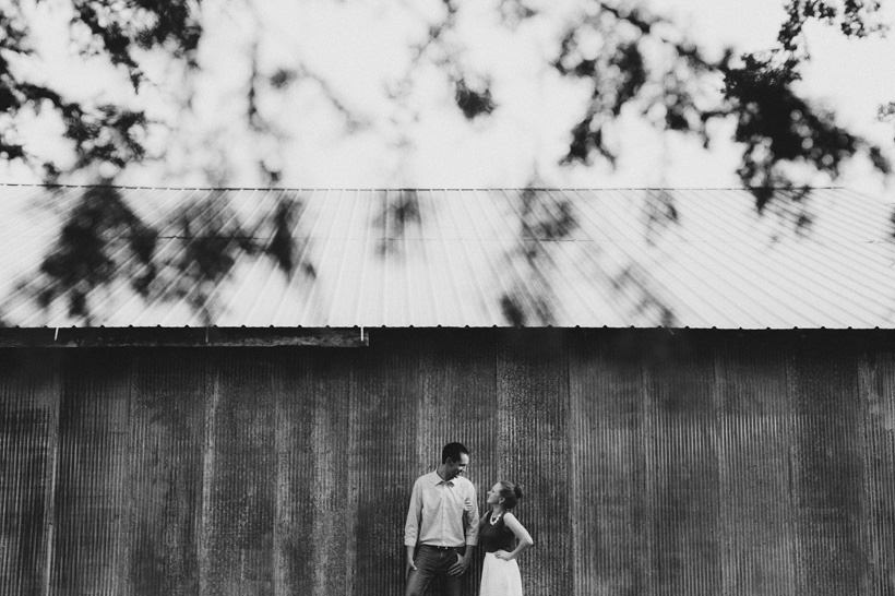 Erin and Scott stand near a rustic shed