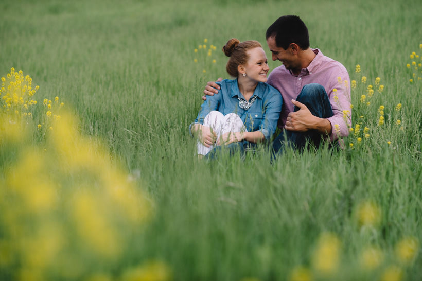 Erin and Scott huddled in a field with flowers