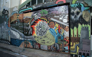 6. Gang Festival: An Australian-Indonesian Artists Exchange: Haema Sivanesan While in Sydney, Taring Padi was invited to paint a 3 x 2.5 metre panel space installed on May Lane, St Peters. They focussed on military 'collaboration' between Australia and Indonesia and the recent mistreatment of refugees from West Papua. Image Courtesy of Gang Festival The Gang Festival took place in the inner-city Sydney suburbs of Chippendale and Surry Hills, 12-29 January 2006