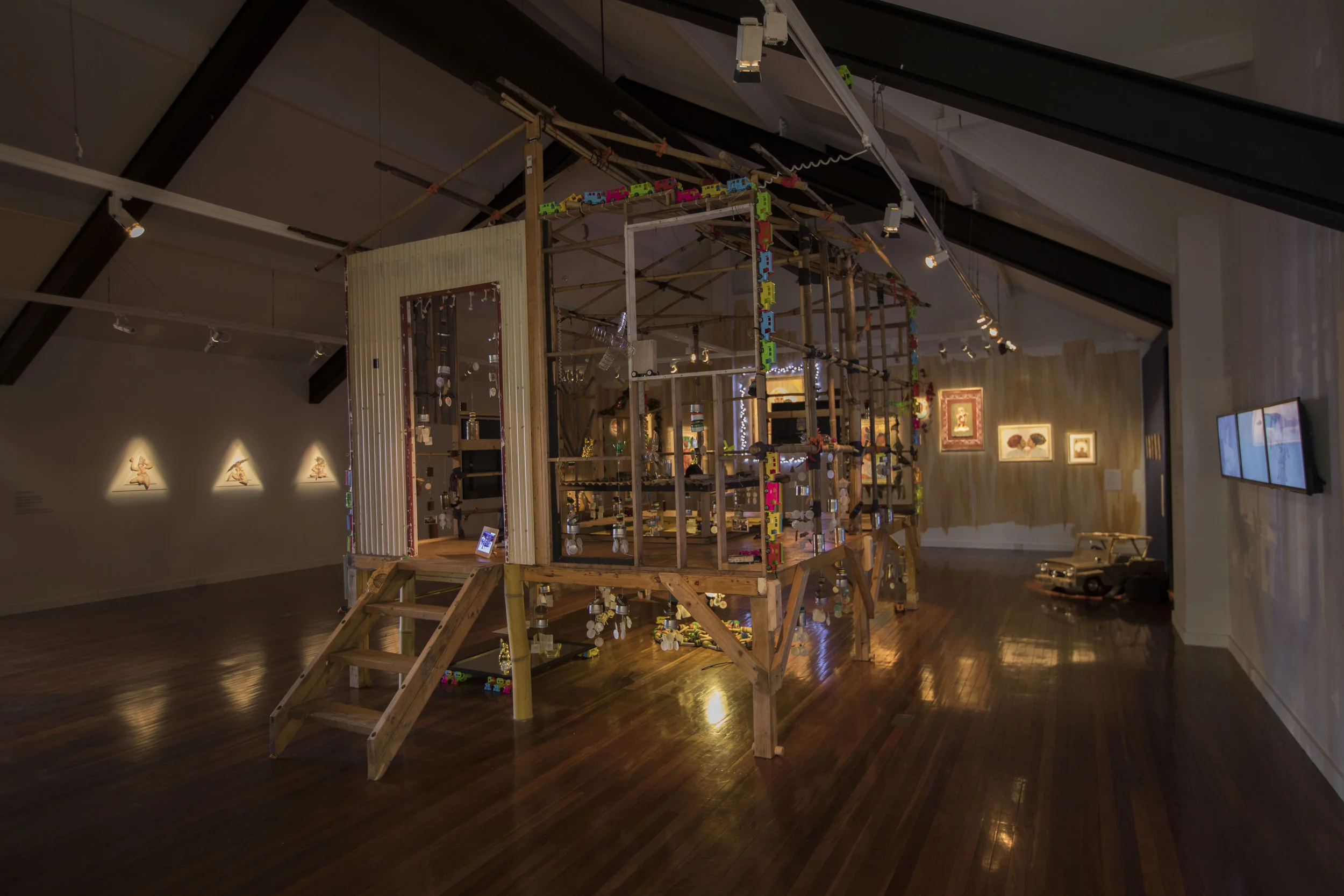 Balik Bayan , exhibition installation detail, Blacktown Arts Centre, 2017, with (from left): Ala Paredes, ‘Power Pose’ series, 2017, articulated paper puppets; Alwin Reamillo, Bayanihan Hopping Spirit House, 2015–17, mixed media, courtesy Urban Theatre Projects; Marikit Santiago, installation of paintings and sculptures, 2017; Melissa Ramos, Distant Memories , 2017, 3-channel video transferred from super-8 film, 6 mins 41 secs duration; image courtesy Blacktown Arts Centre; photo: Sharon Hickey