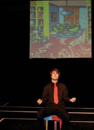 8 Fluorescent Facade: Arkley in Action: ODETTE KELADA Patrick McCarthy in character(s), scene from Fluorescent Facade, with a projection of Howard Arkley's Mod Style, 1992. Photograph by Mary Evans