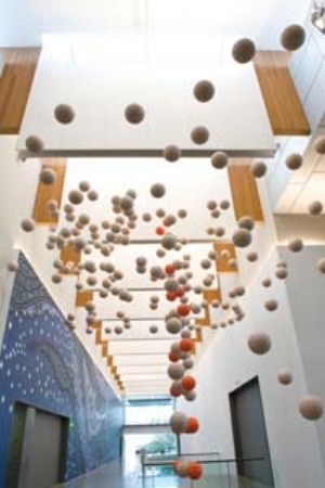 5 Land, sea and sky: contemporary art of the Torres Strait Islands: ALISA DUFF Installation view with Kevin O’Brien's Family Tree , 2011, marine polystyrene floats, stainless steel cable, timber, paint, polyethelene netting, 5.8 x 12.4 x 5.8m (installed, approx.); and (left) Alick Tipoti's mural Kaygasiw-Usul Trail of dust underwater created by the shovel nose shark)… Milky way , 2011, 7.5 x 53.48m. Both works commissioned for Land, Sea and Sky: Contemporary Art of the Torres Strait Islands