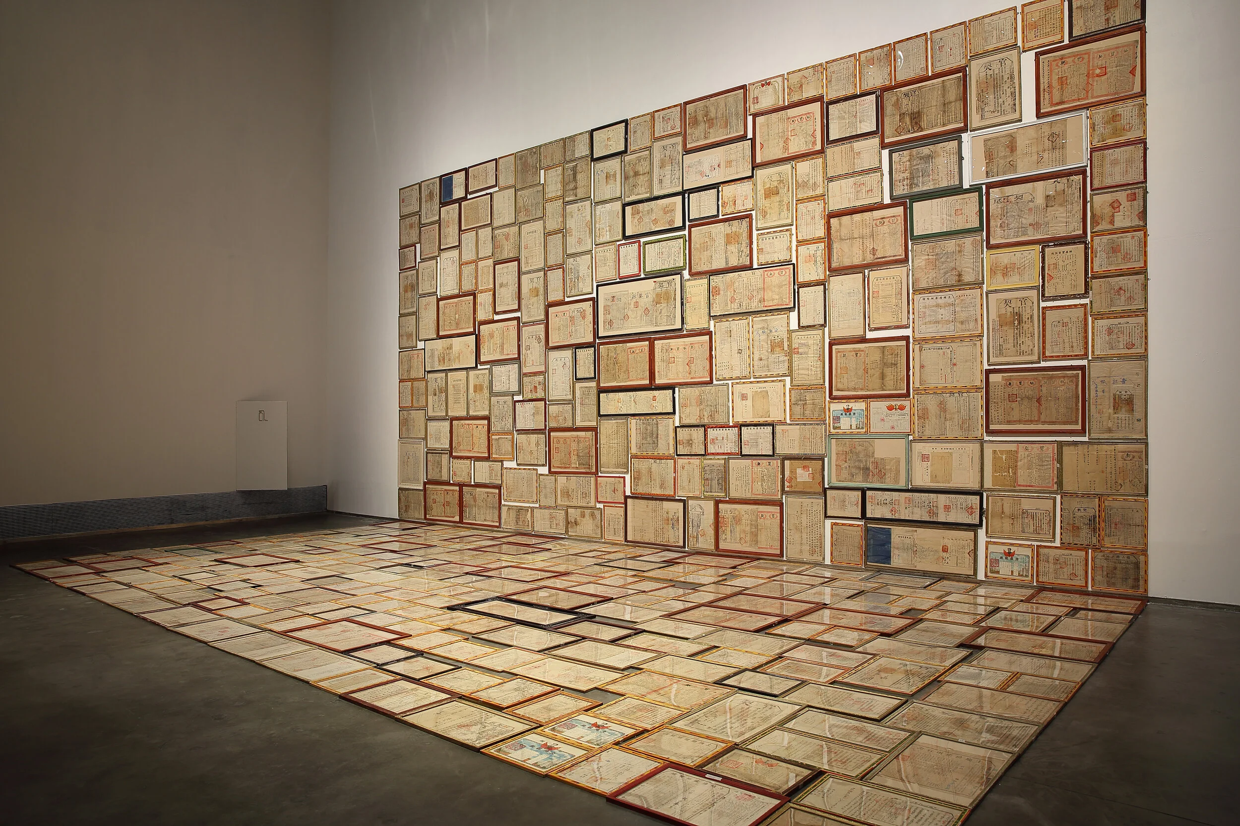 11 fixing the boundaries: mao tongqiang’s  leaseholds ; minerva inwald   Mao Tongqiang,  Leaseholds , 2016, installation view; land ownership papers from various times in China’s history, found picture frames; image courtesy the artist and the White Rabbit Collection, Sydney