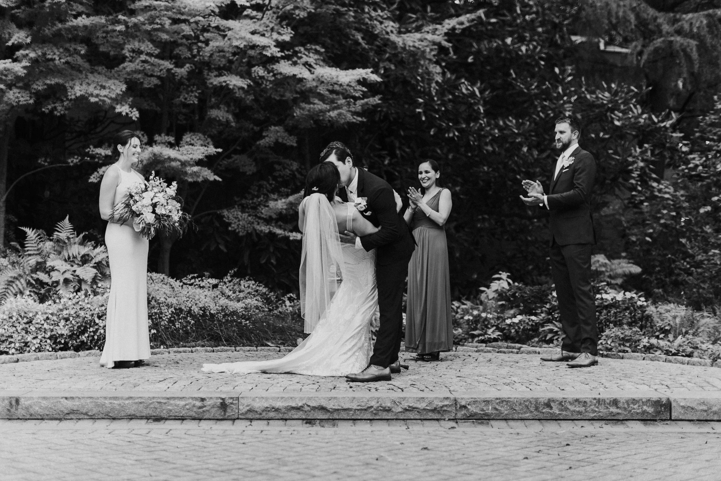 Bride and Groom kiss at wedding ceremony at The Trolley Barn