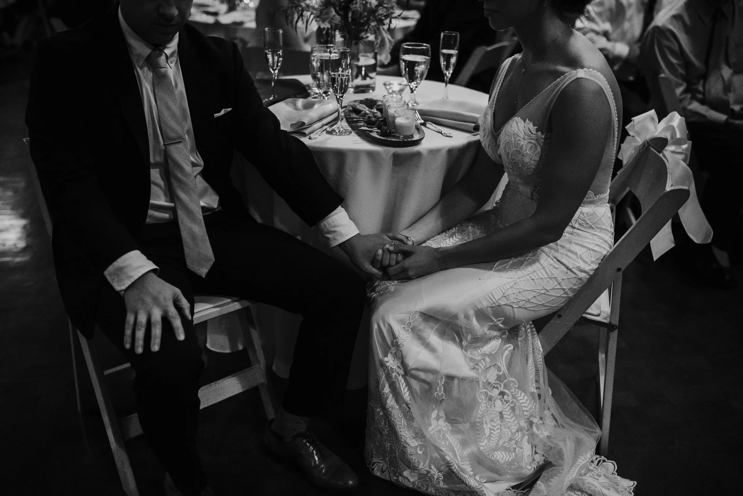 Bride and groom intimately holding hands