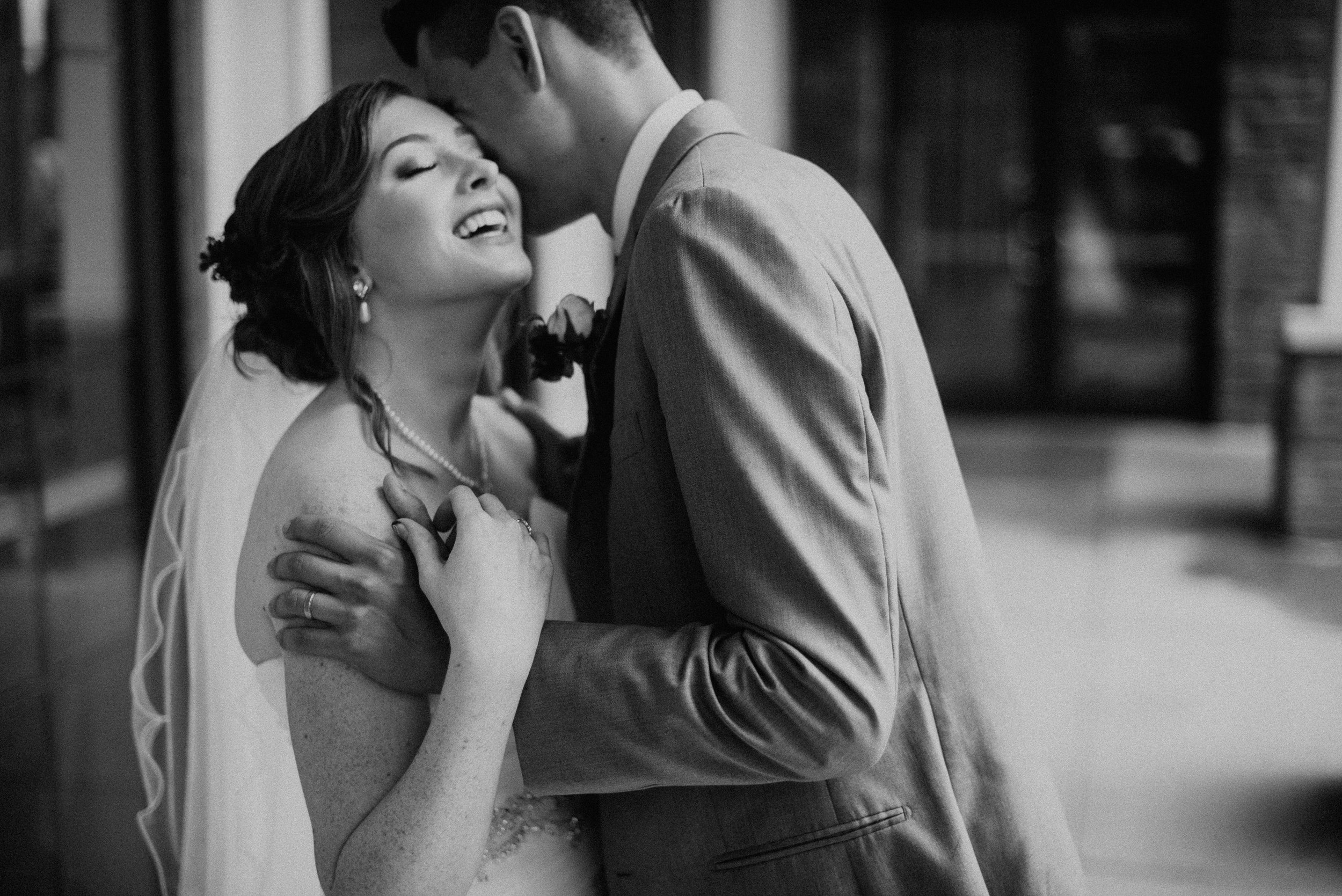 Groom whispering into bride’s ear