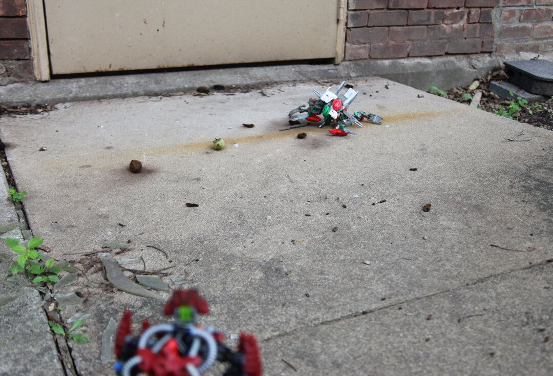 Makuta 2:”I have no clue on, let us stay in the shadows and observe…” (Dameta makes his way into the abandoned courtyard, nearby a derelict Rahkshi Kaita Za sat inactive, poisonous fumes still leaking from it’s two heads, one had been by the looks
