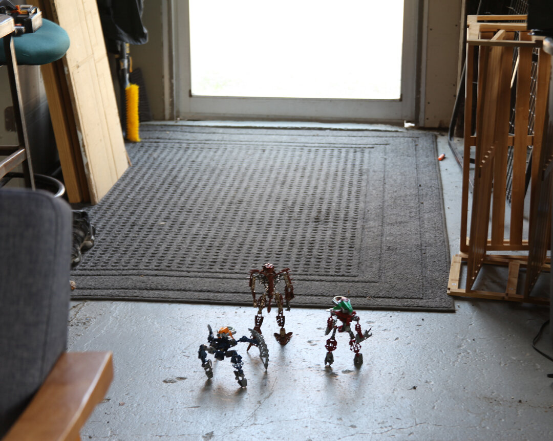 (Avak and two vahki guards step off the monorail to the front gate)