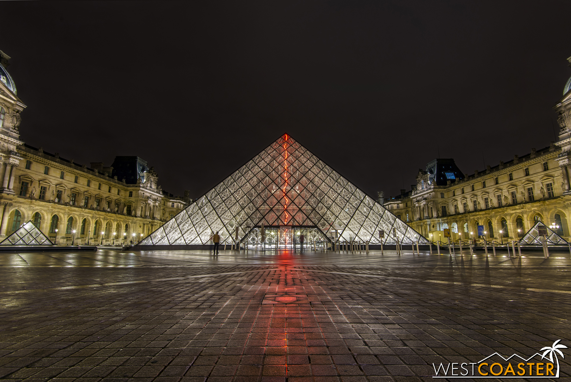 The I.M. Pei-designed glass pyramid of the Louvre, illuminated late at night.