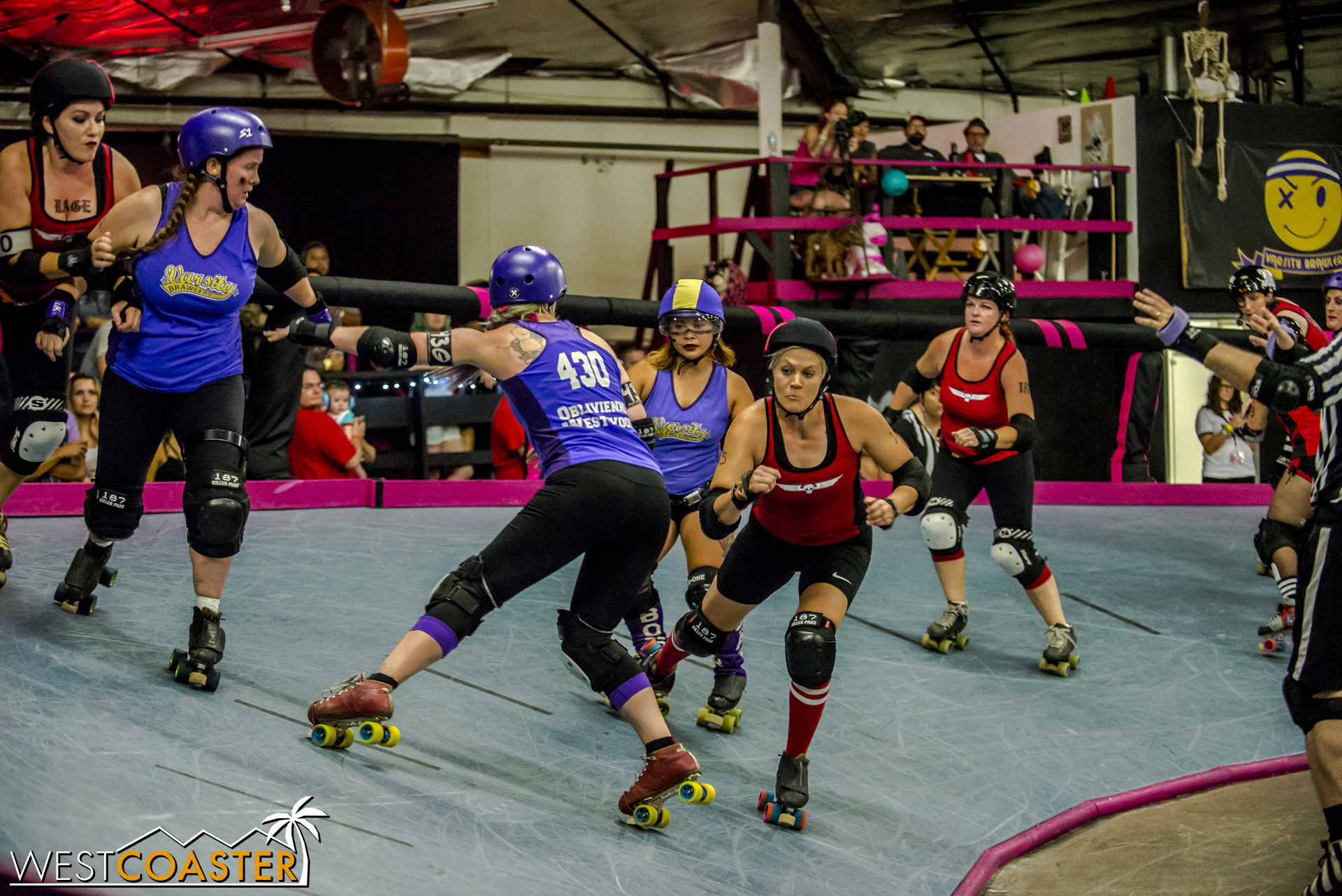 As a blocker attempts to hip check, the red-clad Fight Crew jammer shifts to evade the check.