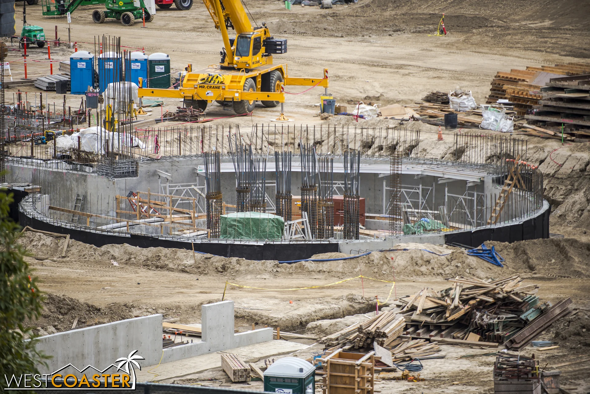 The black material on the soil-side is waterproofing so that when the dirt is back-filled in against the wall, any moisture and liquid in the soil will not be able to leak through the concrete and into the building.