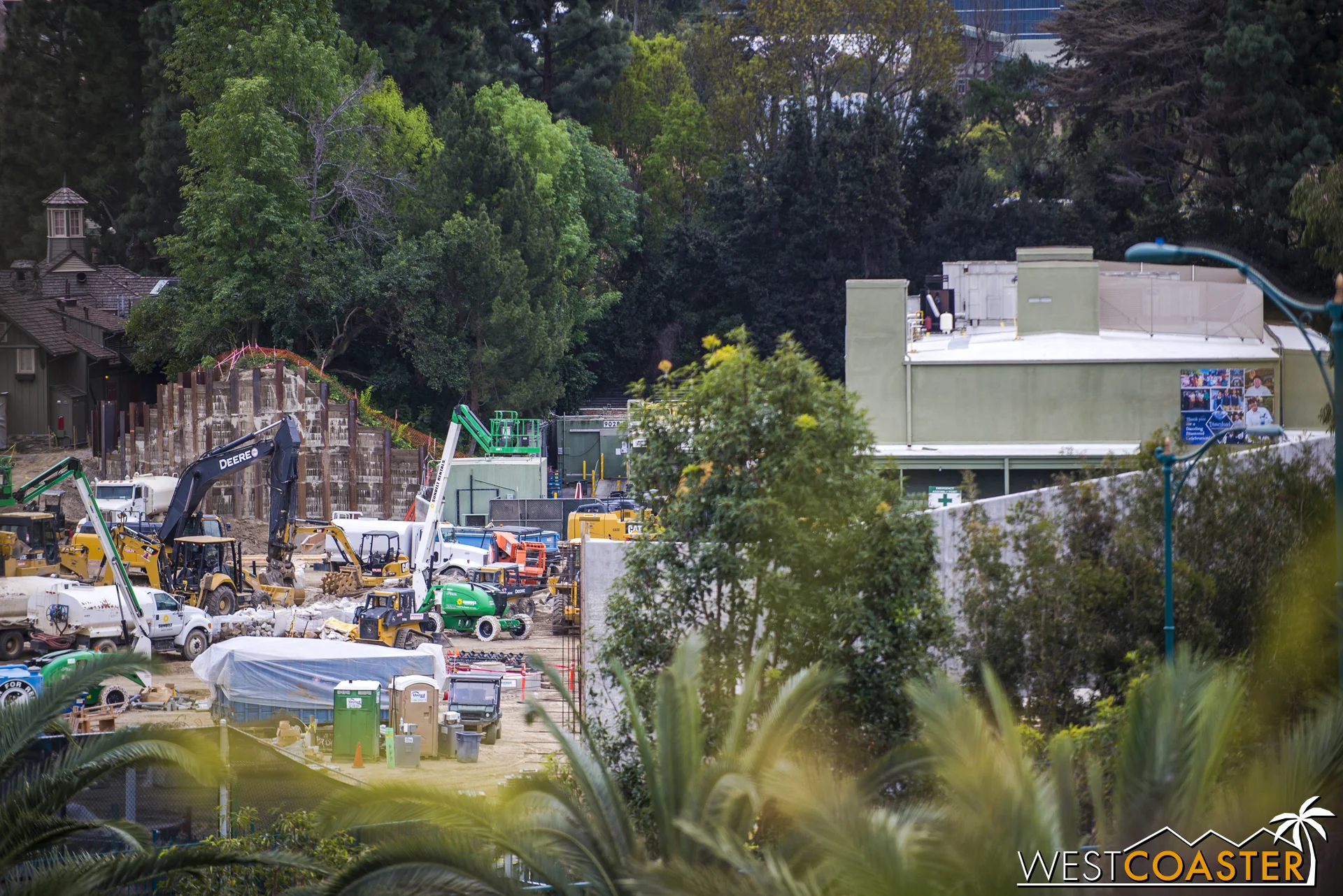 Because, remember, the Disneyland Railroad is still crossing over the Critter Country pathway between The Many Adventures of Winnie the Pooh (green building on the right) and the Hungry Bear Restaurant. So about left of the berm retaining wall in this photo. But then (if we're to trust the rendering Disney previously released), it runs visibly along the reconfigured bank of the Rivers of America.