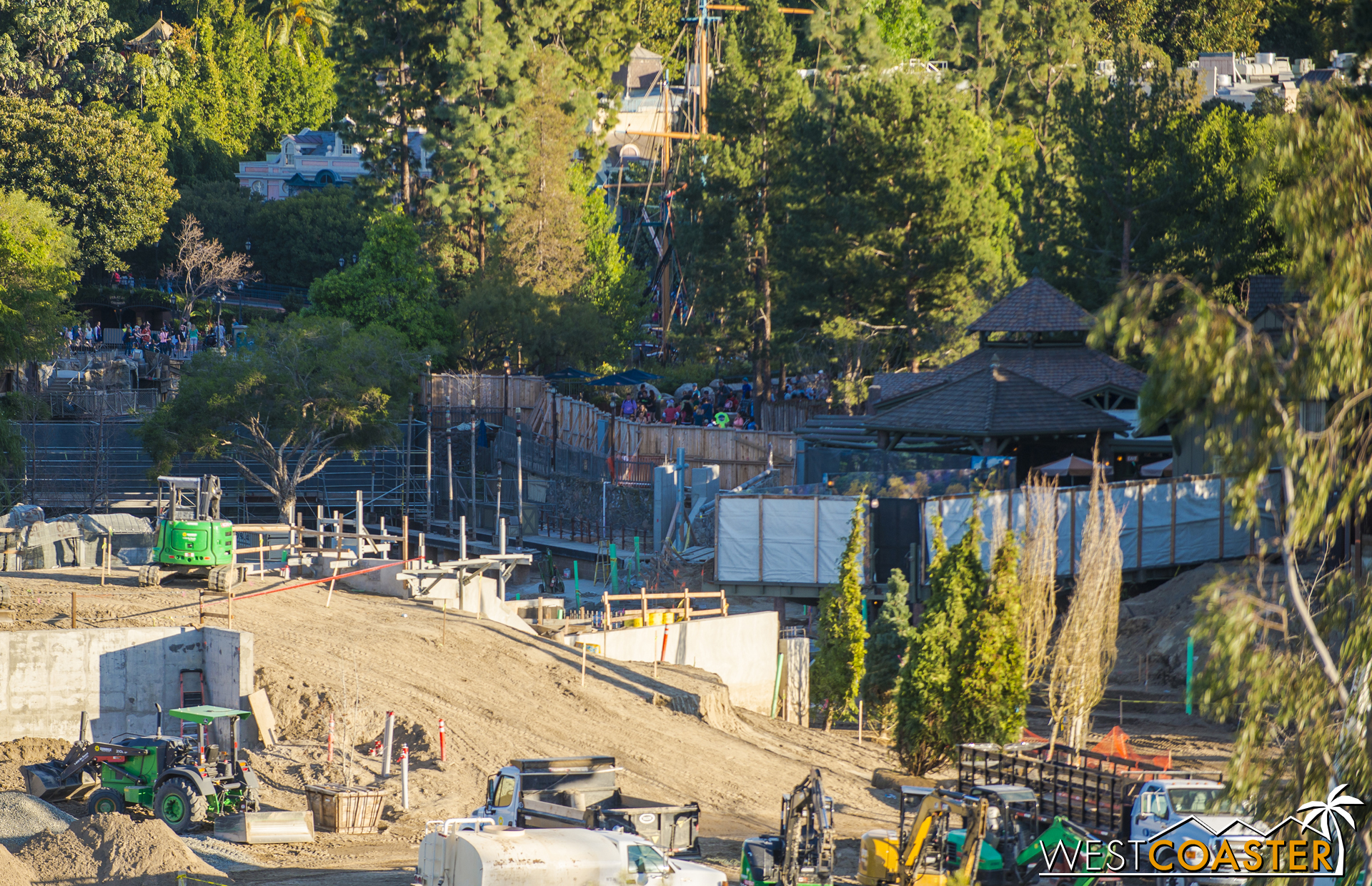  It would appear that the bridge/pathway to the left of the tarp that currently shields the view of Hungry Bear diners from the drained Rivers of America will slowly ramp down and then turn and duck below the railroad tracks before reappearing up and