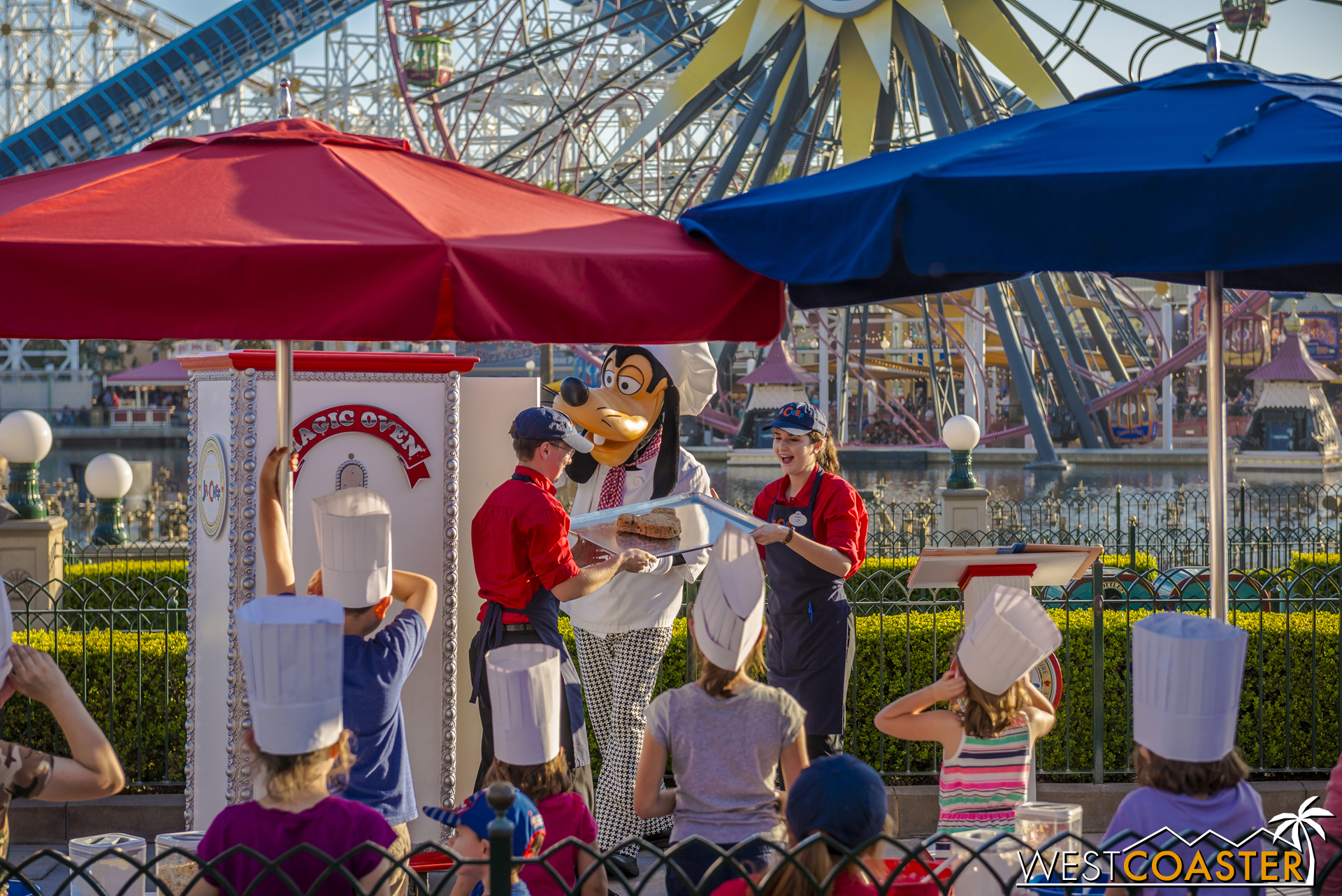 Goofy bringing out the giant Mickey-shaped cookie.