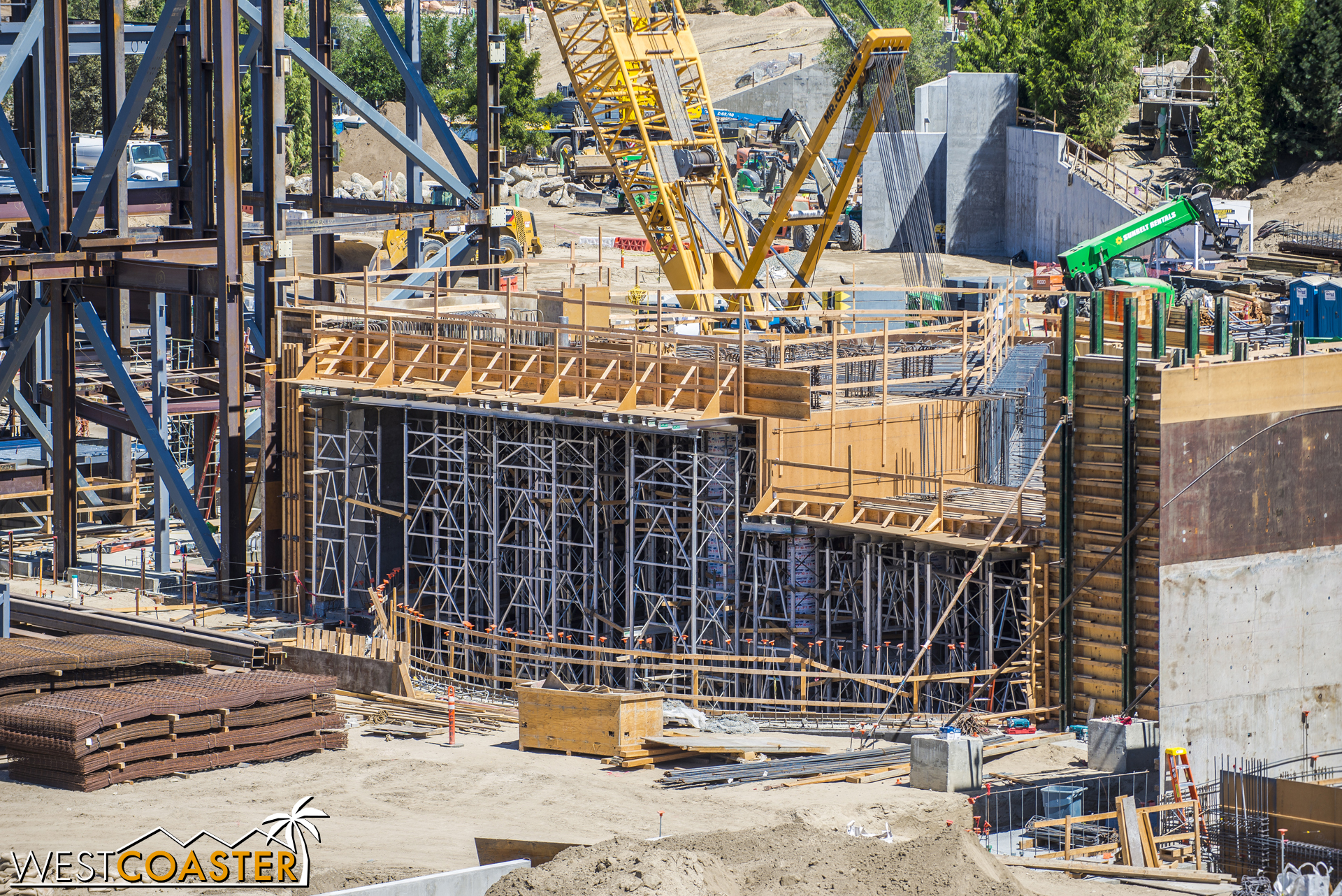  They continue to cast more concrete around steel reinforcement and formwork here, rising out of the ground. 