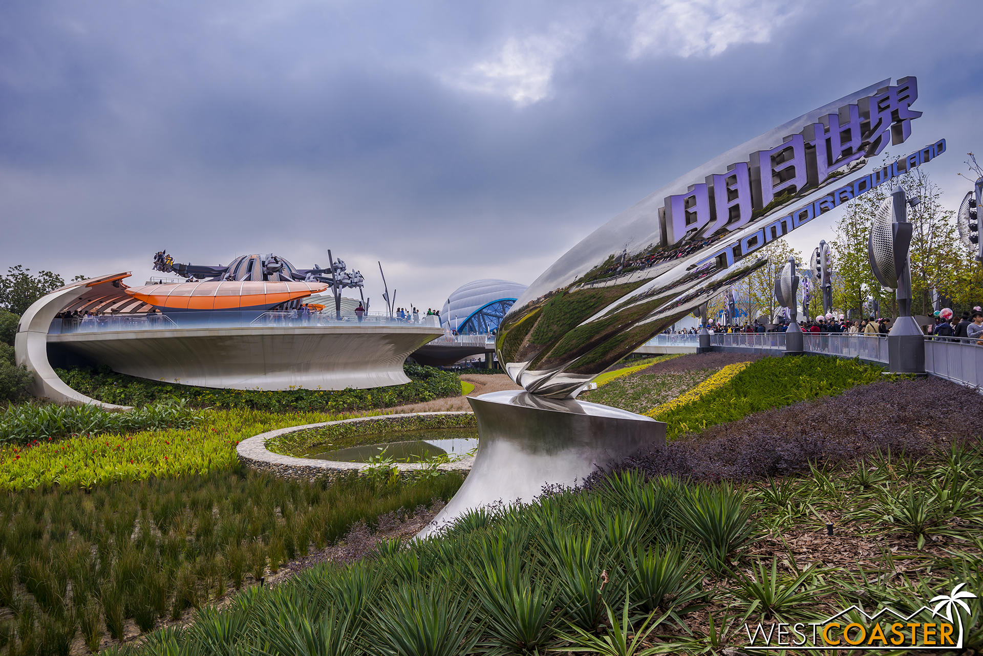 The sleek signage for Tomorrowland beckons. Jet Packs take flight in the background.