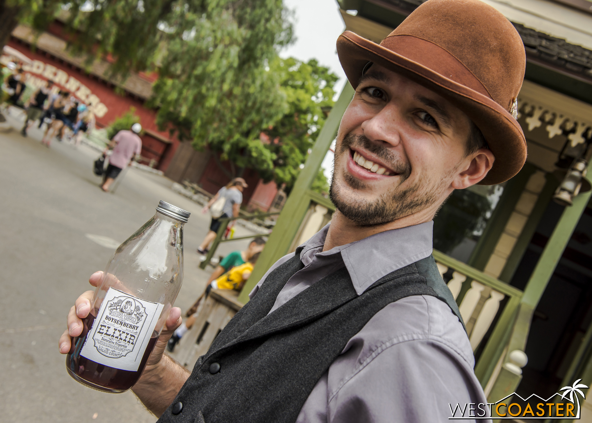  Town Clerk, Kenny Storm, enjoys a swig of Mother Murphy's Magical Boysenberry Elixir in a bottle custom made by park guest.&nbsp; 