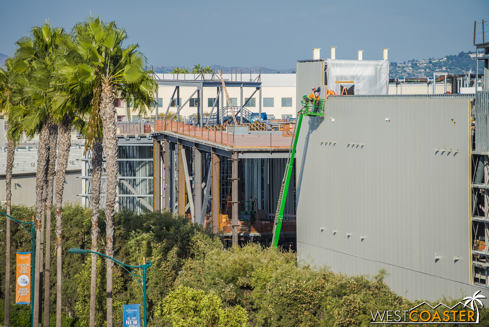  Two construction workers use a lift to fasten the panels. 