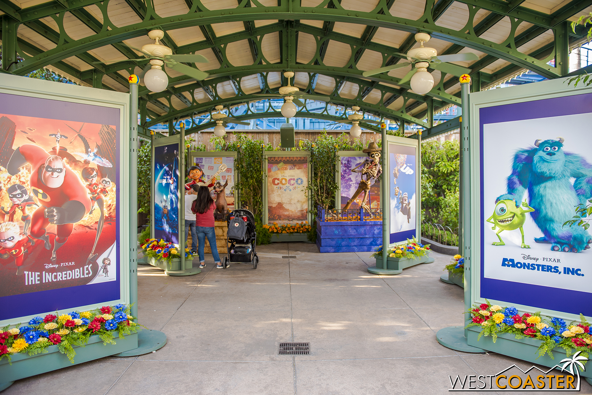  Immediately to the right, where the food festival beer gardens are typically located, is a photo op area with Pixar movie posters and a  Coco  set. 