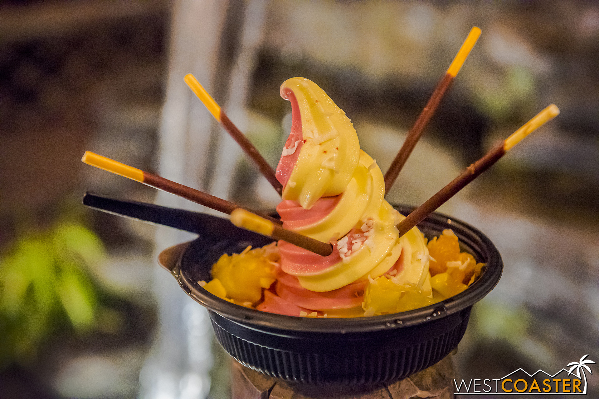  From the Dole Whip stand, order the  Loaded Whip:  pineapple and orange (or raspberry) swirl, exotic fruit (pineapples, mango, lychee, and tangerine in this case), crystallized hibiscus, and Pocky Sticks.  A fantastic, summer-y dessert that is reall