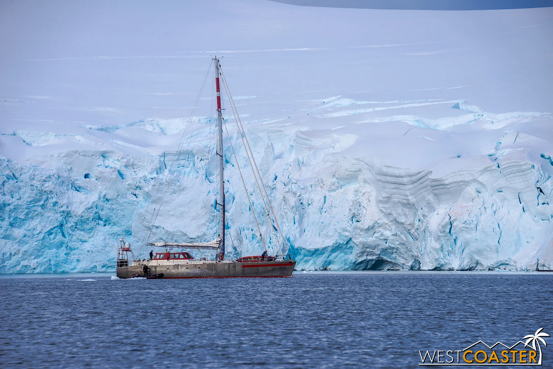 A sailboat in the distance, in front of a heavy blanket of ice.