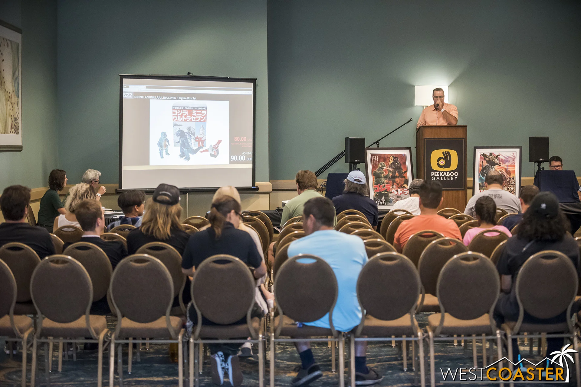 Godzilla fans sit to bid on Godzilla items.