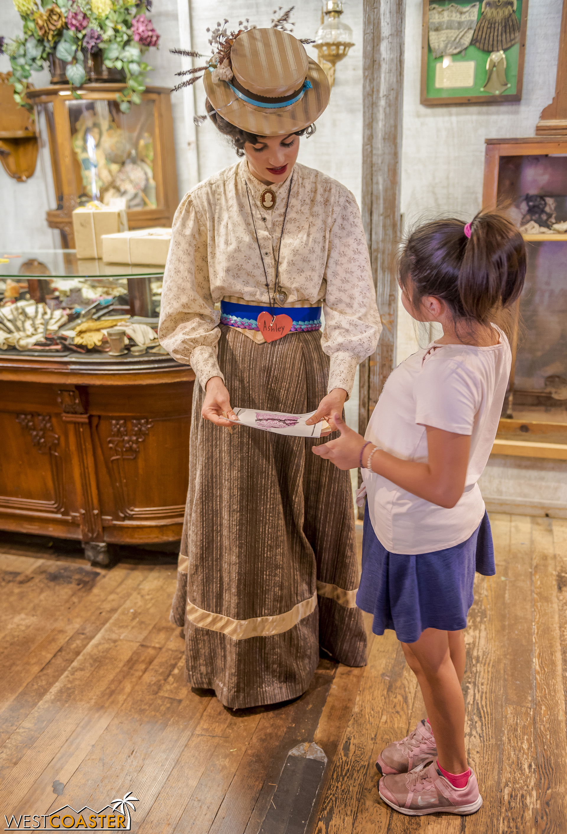  An honorary citizen shows Ashley Kendall a dress design. 