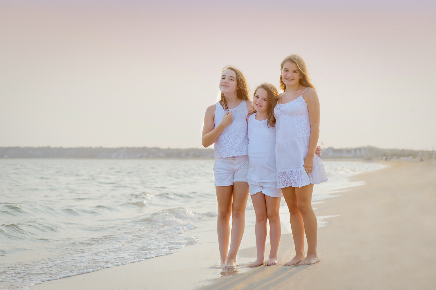 Three Beautiful Sisters standing on the beach and gazing at the 
