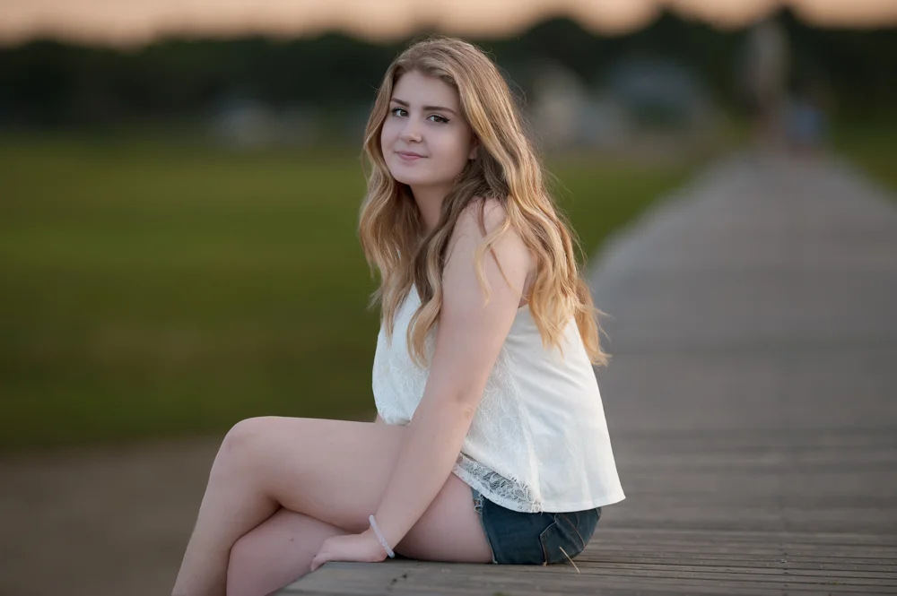 High School Senior sitting on Boardwalk in Sandwich MA during Se
