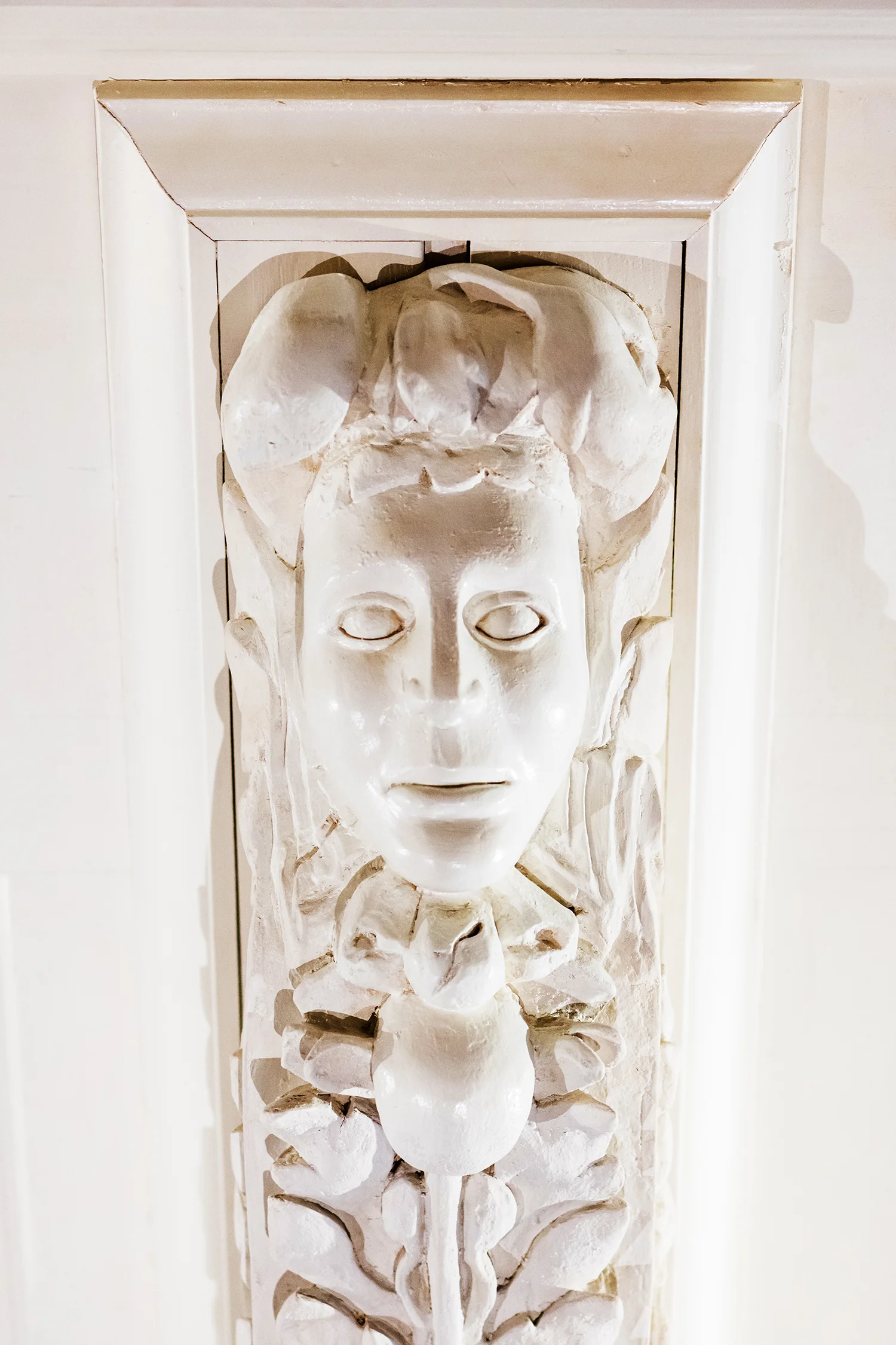 A carving of Hera in one of the wooden brackets framing the Hancock door.
