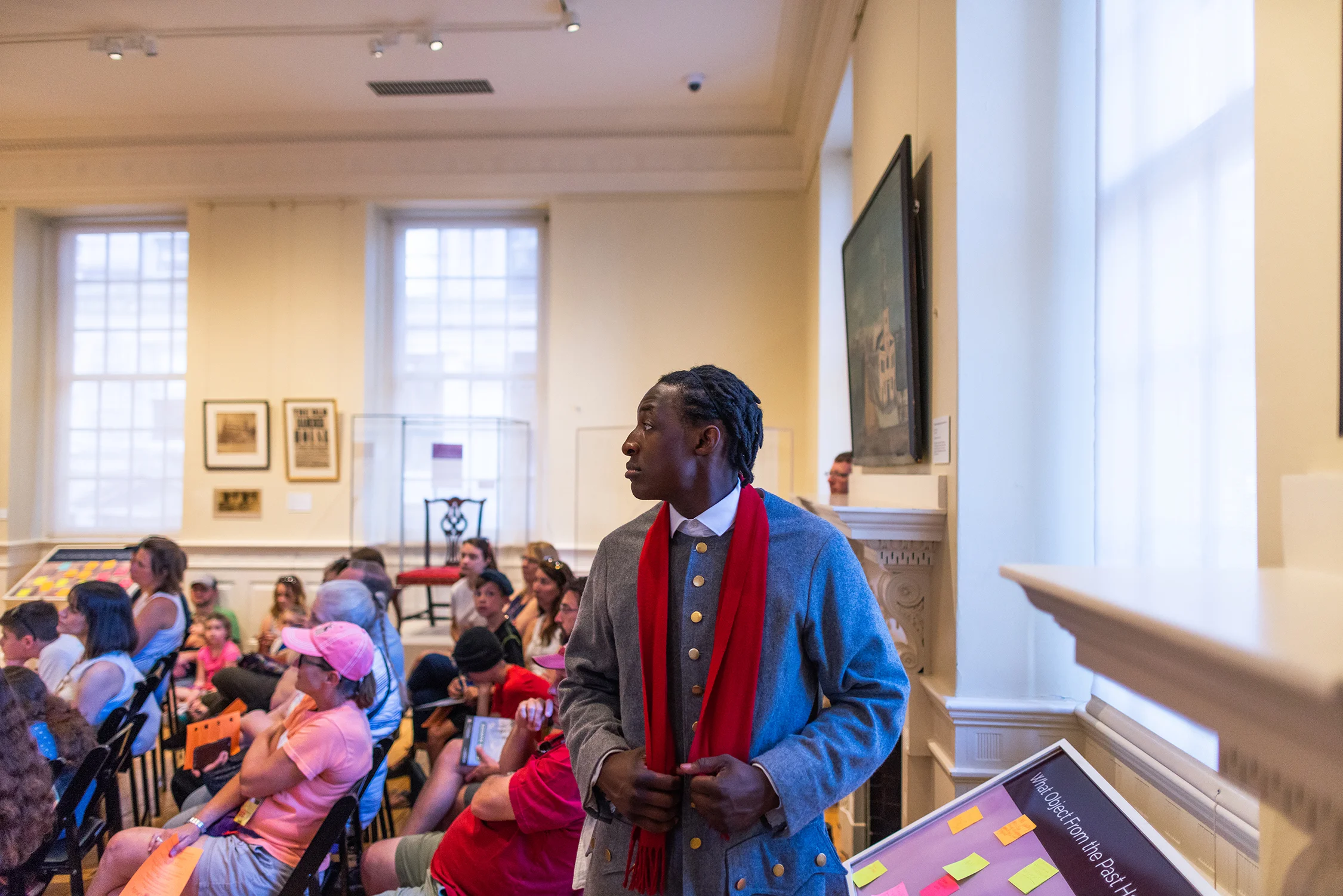 Young black man in red scarf as John Hancock's young son.