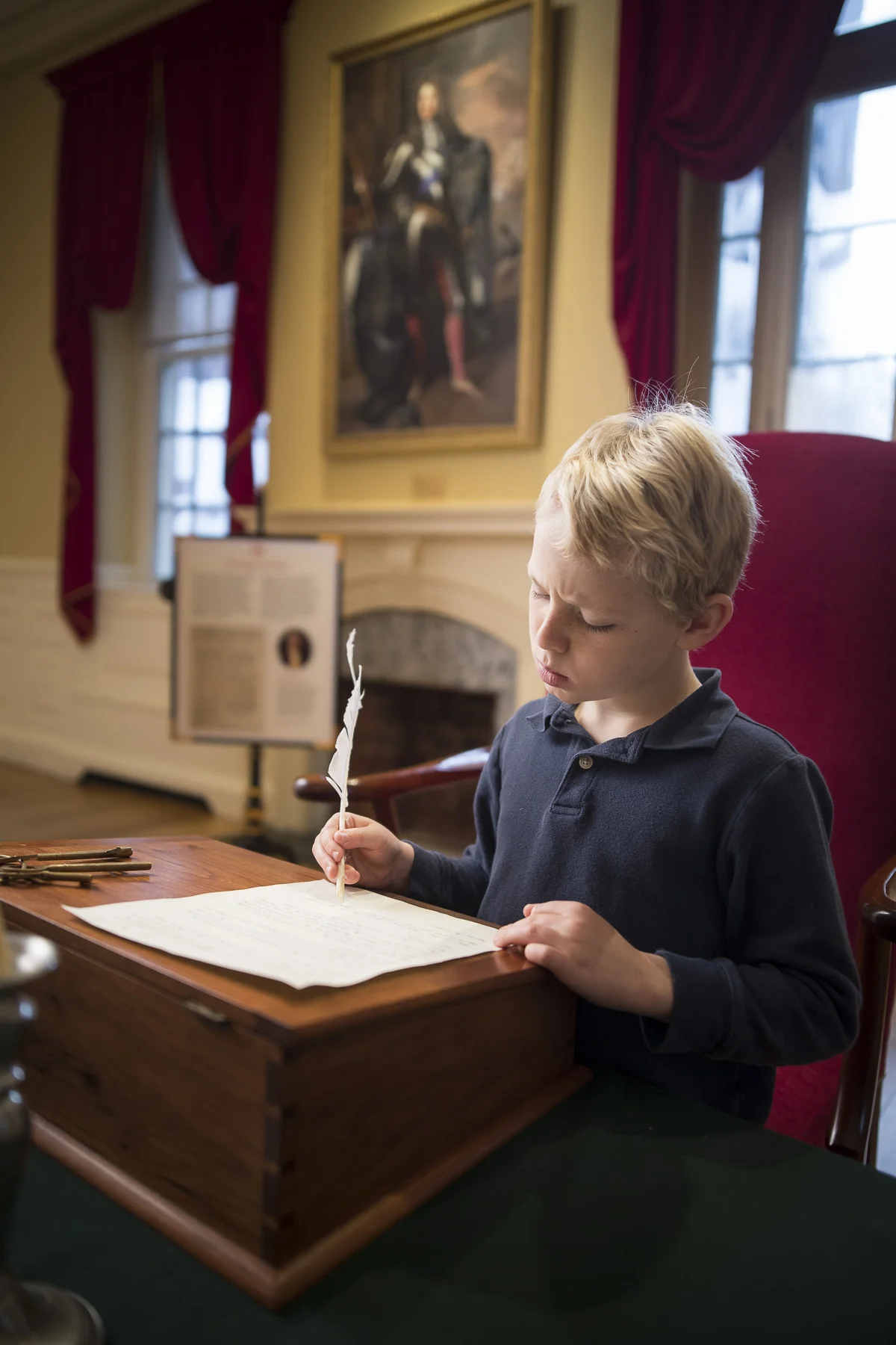 Young boy holding a quill.