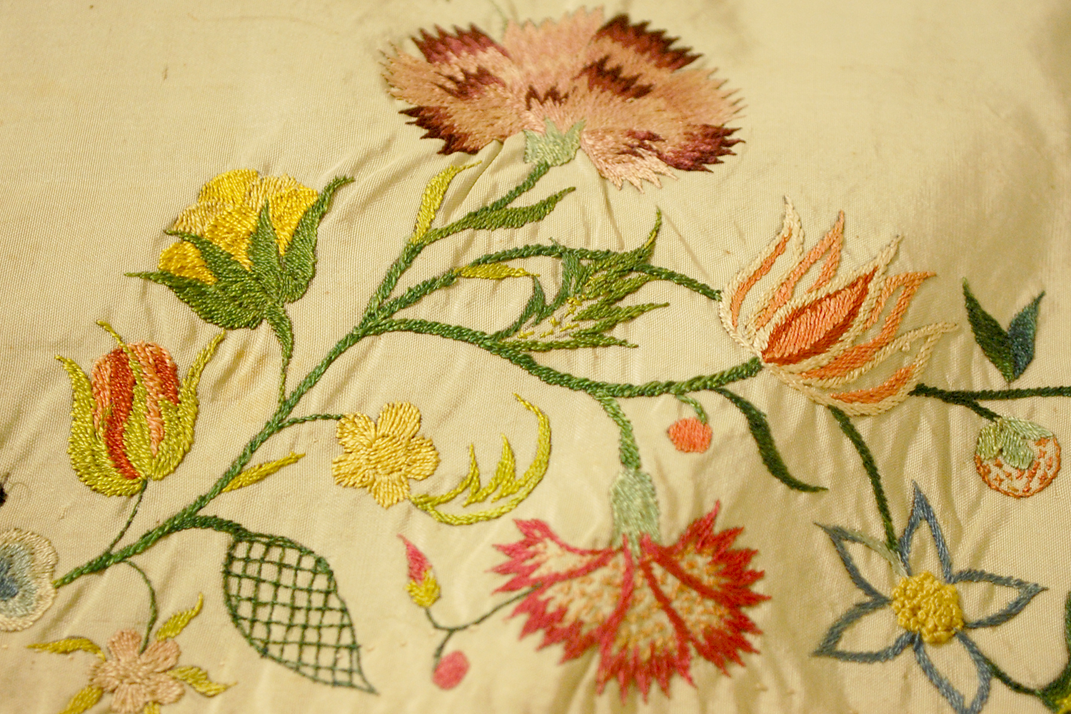 Close up of embroidery on a Colonial Era wedding gown.