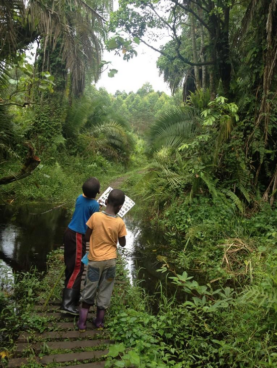Ugandan students with their Rutooro edition of "The Chorus of Kibale" during a rainforest field trip.