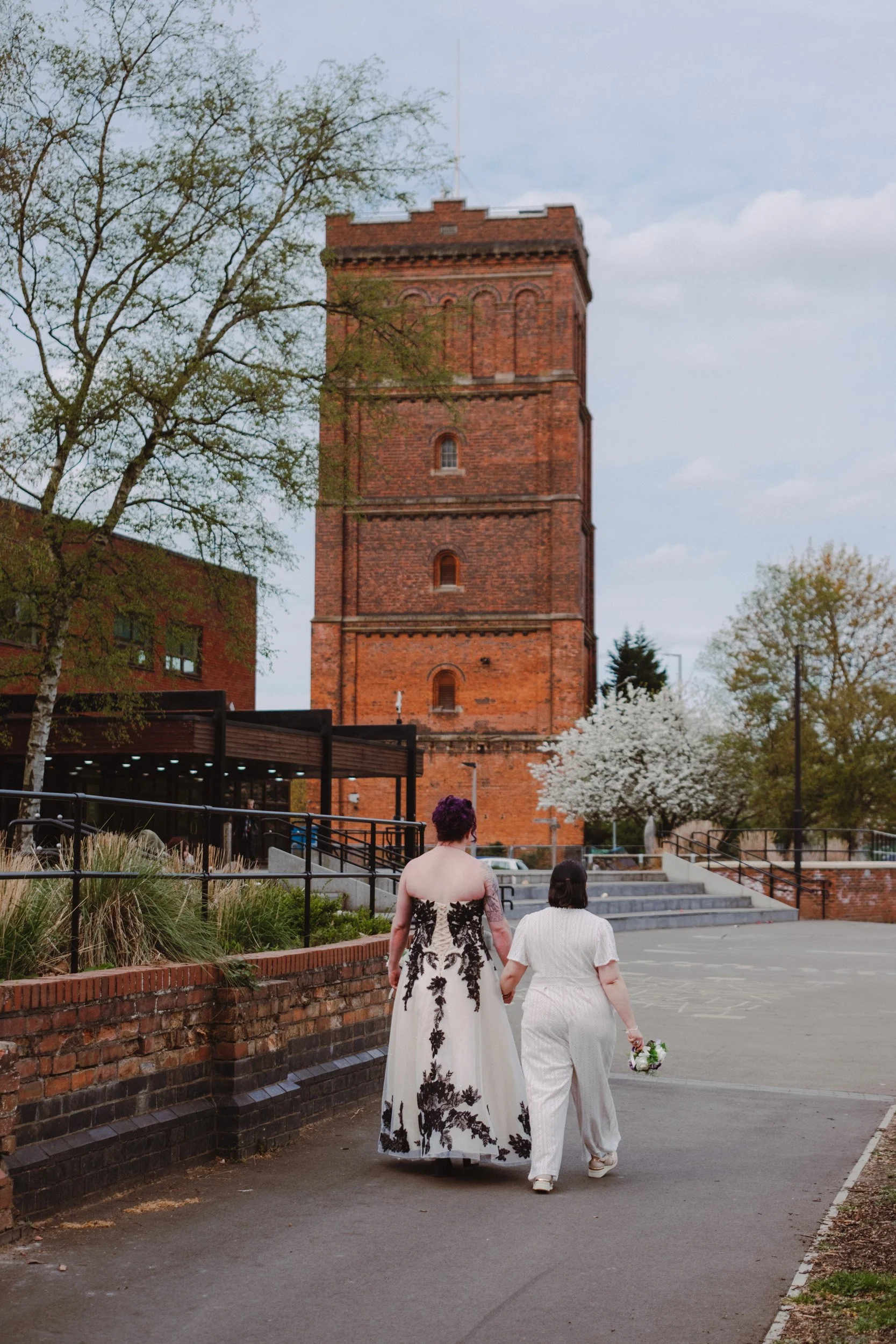 Two brides walking past Burton registration office