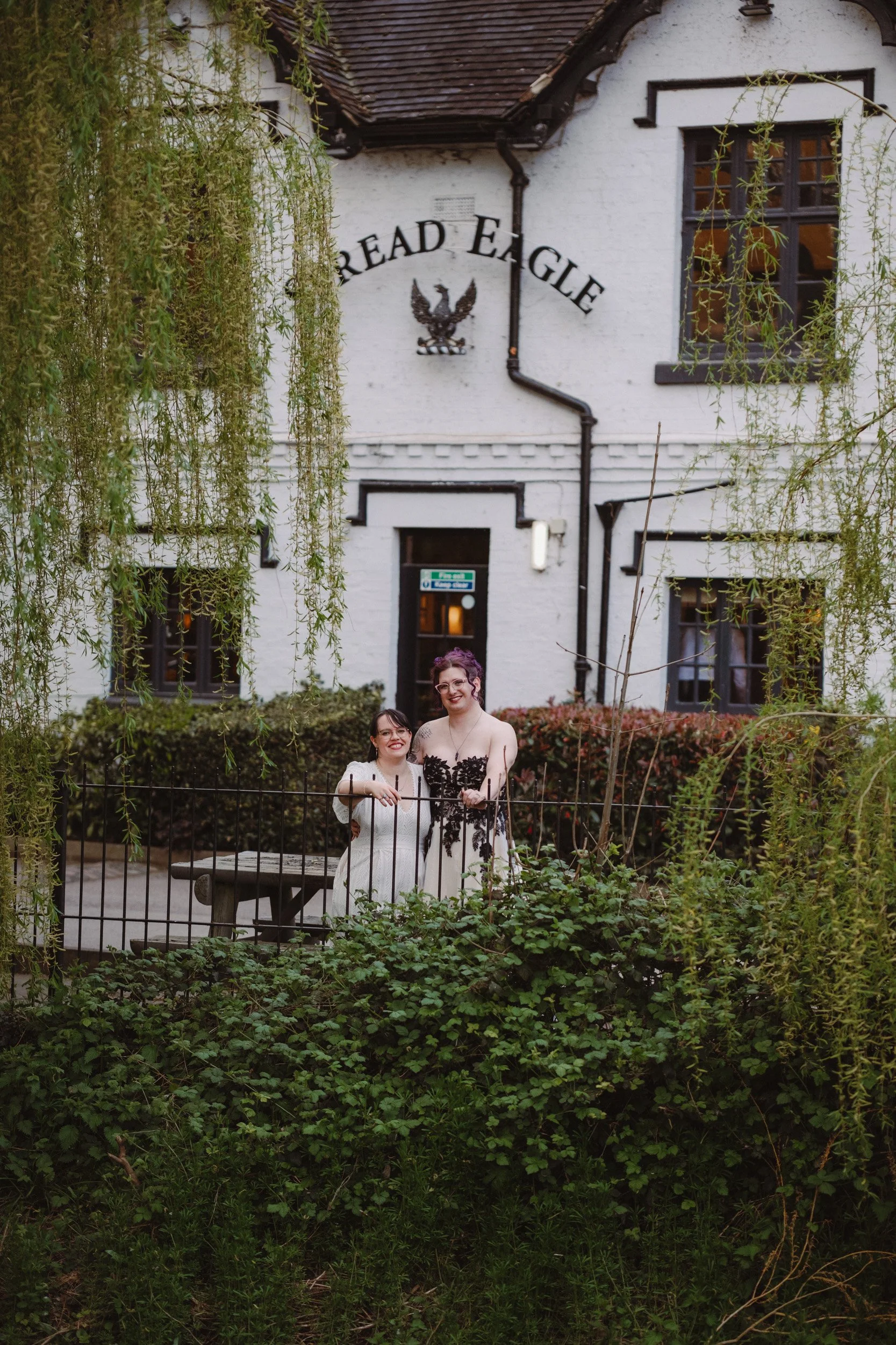 Two brides standing outside the Spread Eagle Pub in Rolleston Burton upon Trent during their wedding reception