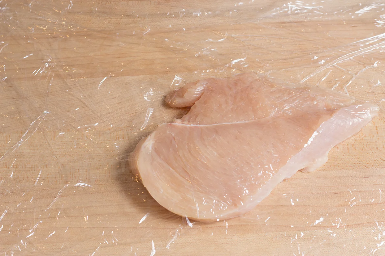 Sprinkle several drops of cold water on top of breast and cover with cling wrap. 