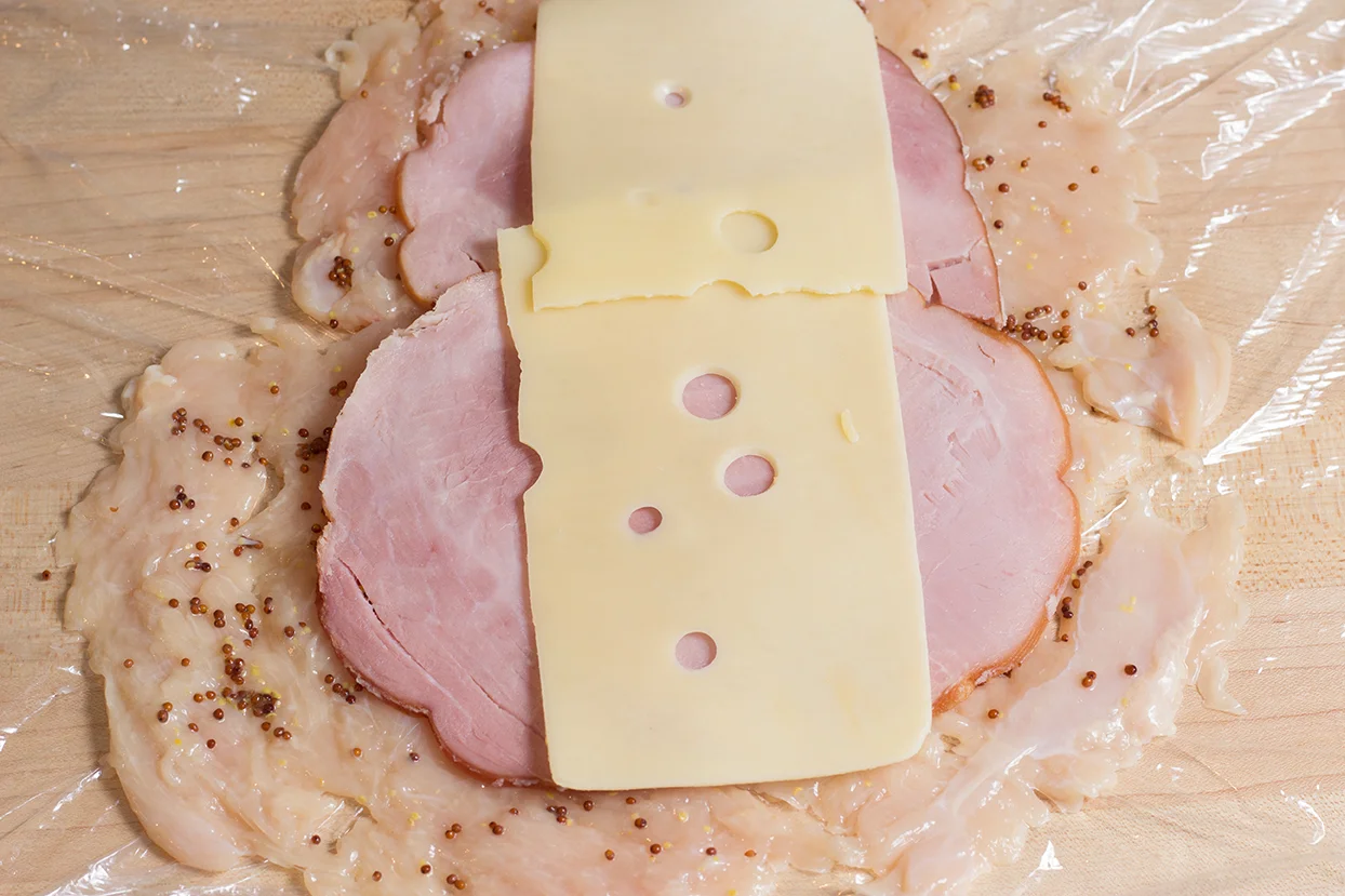 Lay a thinly sliced black forest or rosemary ham on breast. Then add a thinly sliced cheese, swiss or provolone.